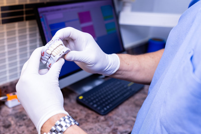 Dr. Kirsch holding up mold of teeth with dental veneers