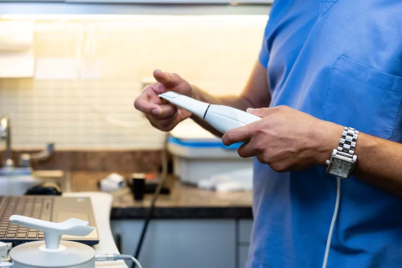 Dental professional holding an intraoral scanner in a clinic setting